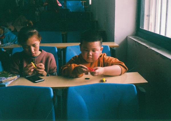 A parent and child sitting together at a table, engaged in a learning or testing activity