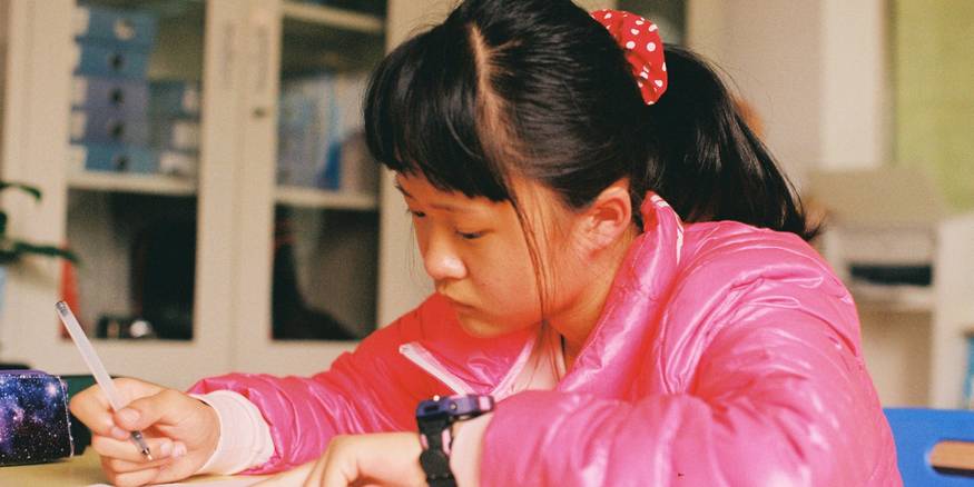 A thoughtful child engaged in learning, representing the profile of a gifted student