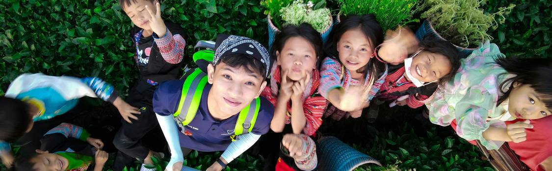 A group of children collaborating on a large creative project or hands-on enrichment activity, fostering teamwork and higher-level thinking skills