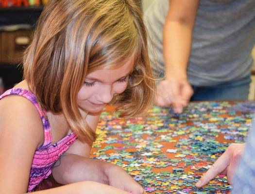 Children and families working together to solve puzzles for fun and learning