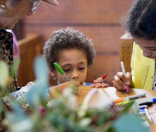 Children or a family collaborating on observation puzzles at a table, representing teamwork and focus