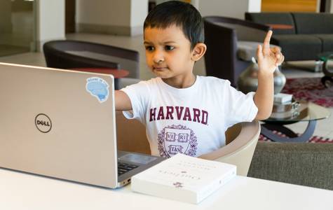 A parent and child sitting at a computer or printer, reviewing or printing an IQ test results summary together