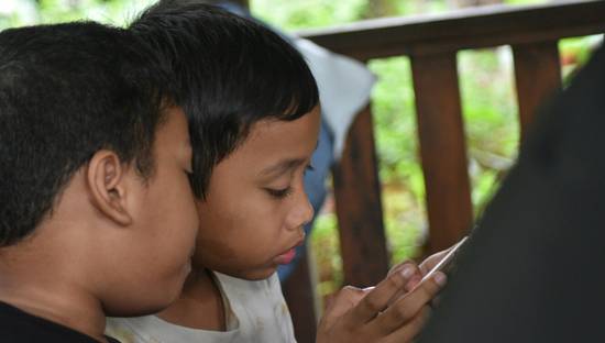 A parent and child using a tablet together to browse educational resources